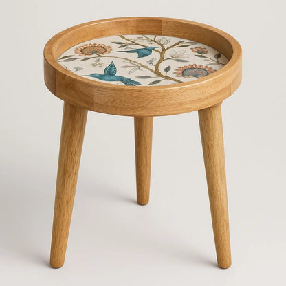 Small round wooden table with a decorative top on a plain background
